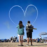Zauscher sehen ein von einem Kunstflugteam in den Himmel gezeichnetes Herz