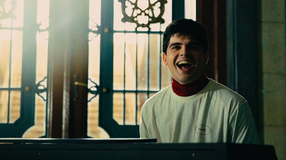 Musiker Íñigo Quintero sitzt hinter dem Klavier