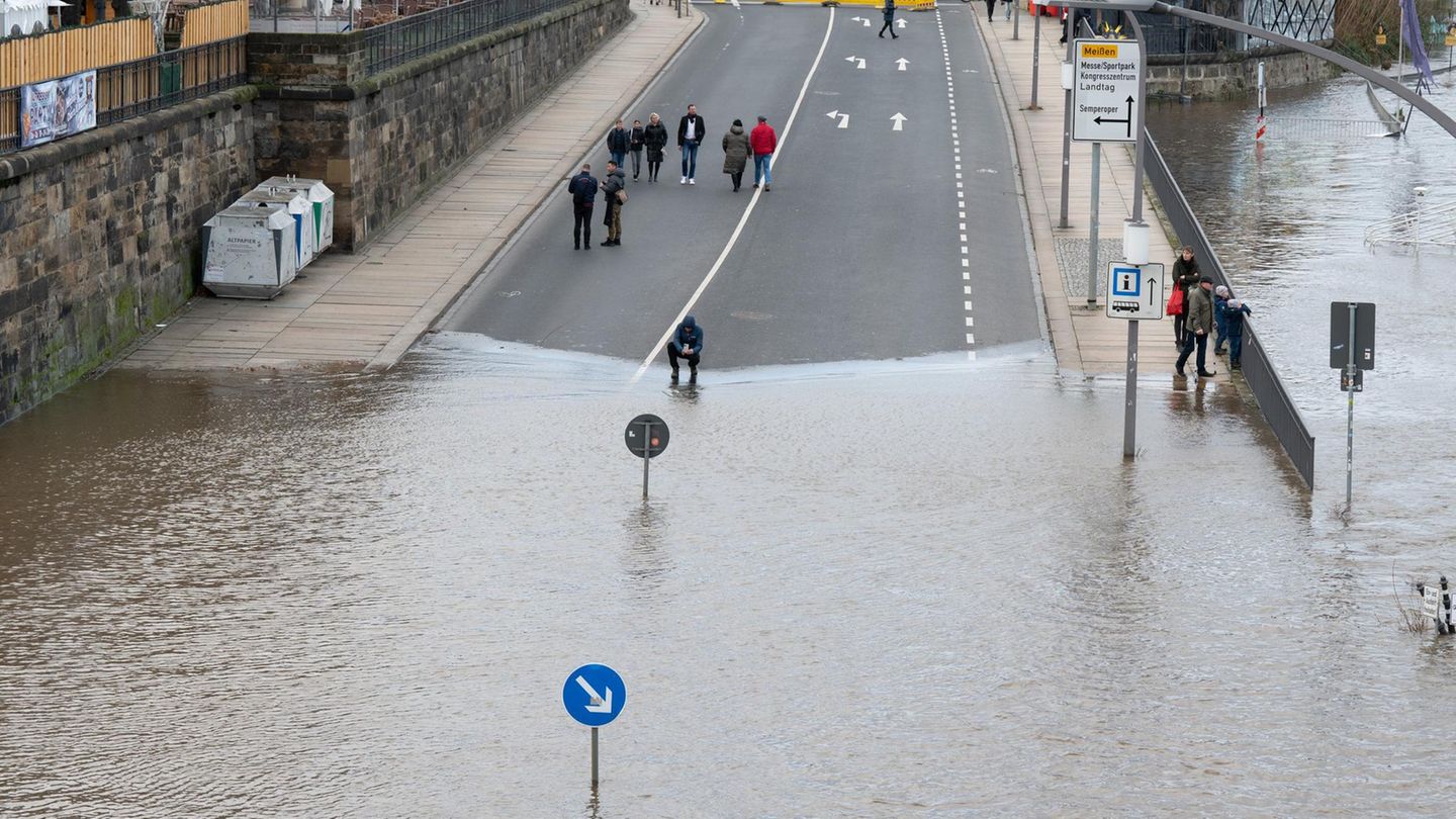 Das Hochwasser der Elbe umspült ein Verkehrsschild am Terrassenufer in Dresden