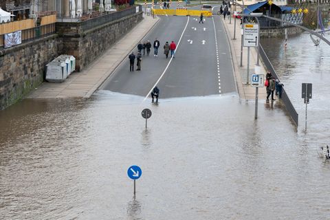 Das Hochwasser der Elbe umspült ein Verkehrsschild am Terrassenufer in Dresden