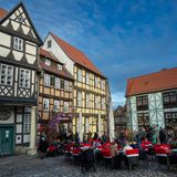 Fachwerkhäuser an einem Platz mit Tischen und Stühlen