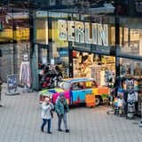 Menschen vor einem Geschäft in einer Einkaufsstraße