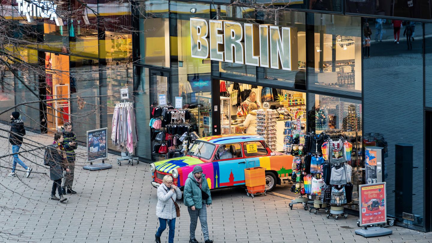 Menschen vor einem Geschäft in einer Einkaufsstraße