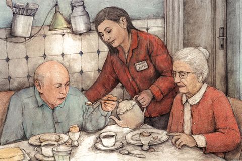 Eine Pflegekraft schenkt einem älteren Paar beim Frühstück Kaffee ein.