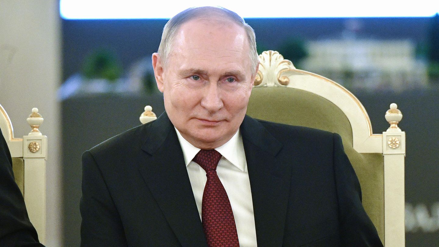 Russland: Wladimir Putin sitzt auf einem Stuhl und lächelt