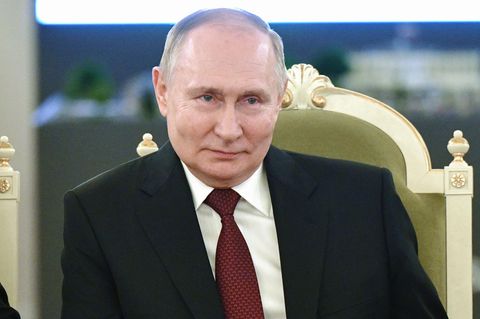 Russland: Wladimir Putin sitzt auf einem Stuhl und lächelt
