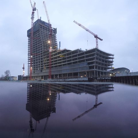 Signa-Gruppe von René Benko: Die Baustelle des Elbtowers in Hamburg spiegelt sich auf dem Display eines Tablets