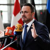 Luxemburgs Ministerpräsident Xavier Bettel steht vor Mikros und gestikuliert