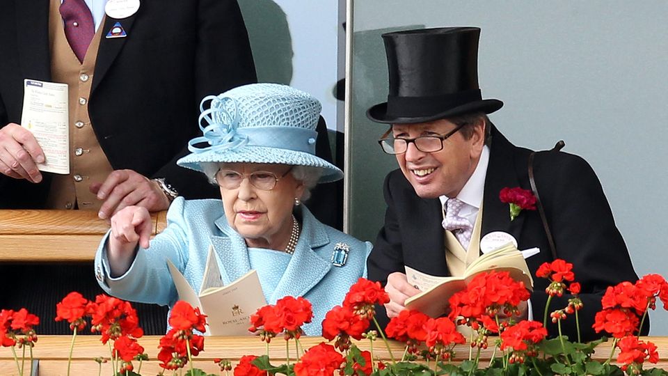 Königin Elizabeth II. unterhält sich mit einem Freund, während sie die Vorführung der Pferde beim Royal Ascot beobachtet.