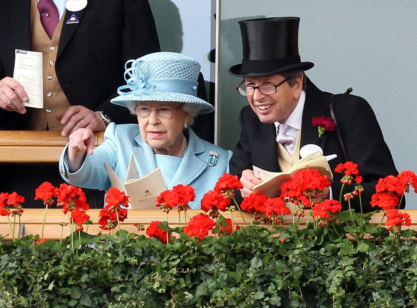 Royale Freundschaften Königin Elizabeth II. unterhält sich mit einem Freund, während sie die Vorführung der Pferde beim Royal Ascot beobachtet.