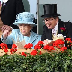 Königin Elizabeth II. unterhält sich mit einem Freund, während sie die Vorführung der Pferde beim Royal Ascot beobachtet.