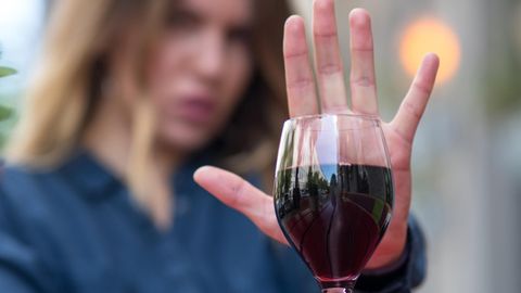 Frau zeigt mit ihrer Hand, dass sie keinen Alkohol will