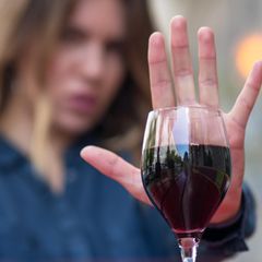 Frau zeigt mit ihrer Hand, dass sie keinen Alkohol will
