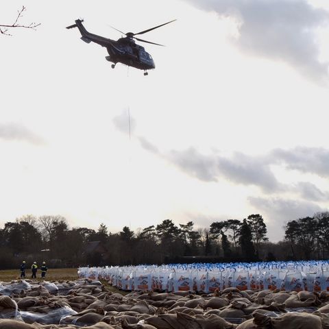 Ein Hubschrauber der Bundespolizei transportiert in Oldenburg Sandsäcke, um die Region vor dem Hochwasser zu schützen