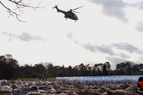 Ein Hubschrauber der Bundespolizei transportiert in Oldenburg Sandsäcke, um die Region vor dem Hochwasser zu schützen