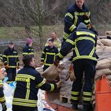 Helfer sichern Deich