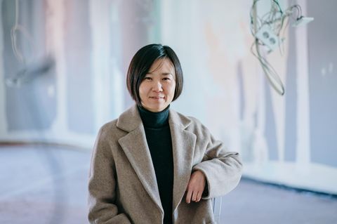 Cho Nam-Joo, eine Frau mit Pagenschnitt, lehnt an einer Brüstung