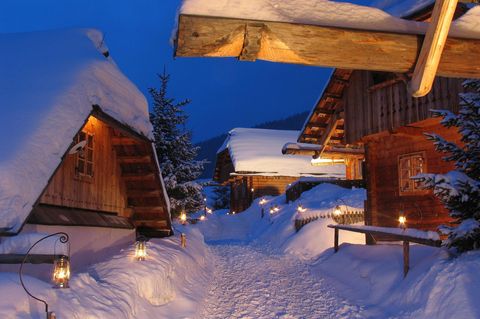 Almdorf Seinerzeit in Kärnten: Hütten im Tiefschnee bei Dämmerung