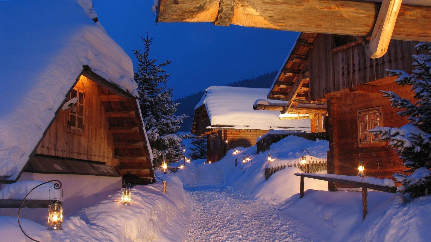 Almdorf Seinerzeit in Kärnten: Hütten im Tiefschnee bei Dämmerung