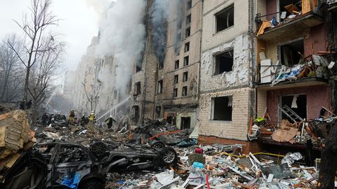 Beschädigte Autos liegen neben einem zerstörten Wohnhaus in Kiew nach einem russischen Angriff