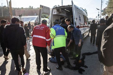 Rettungskräfte kümmern sich nach den Explosionen in der südiranischen Stadt Kerman um einen Verletzten
