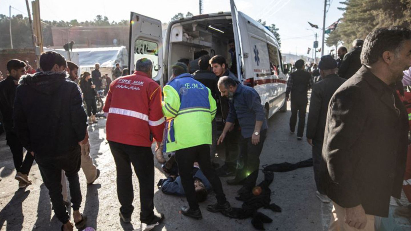 Rettungskräfte kümmern sich nach den Explosionen in der südiranischen Stadt Kerman um einen Verletzten