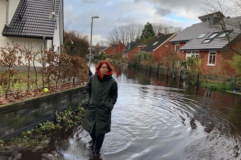 Daina Kuniga-Wendel watet durch das Hochwasser in ihrer Straße in Lilienthal
