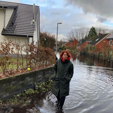 Daina Kuniga-Wendel watet durch das Hochwasser in ihrer Straße in Lilienthal