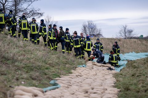 Schutz vor Hochwasser: Feuerwehrleute bilden Kette am Deich