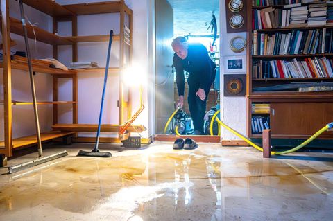 Ein Mann trägt eine Pumpe in seinen Keller im Bremer Stadtteil Borgfeld, der durch das Hochwasser überschwemmt wurde