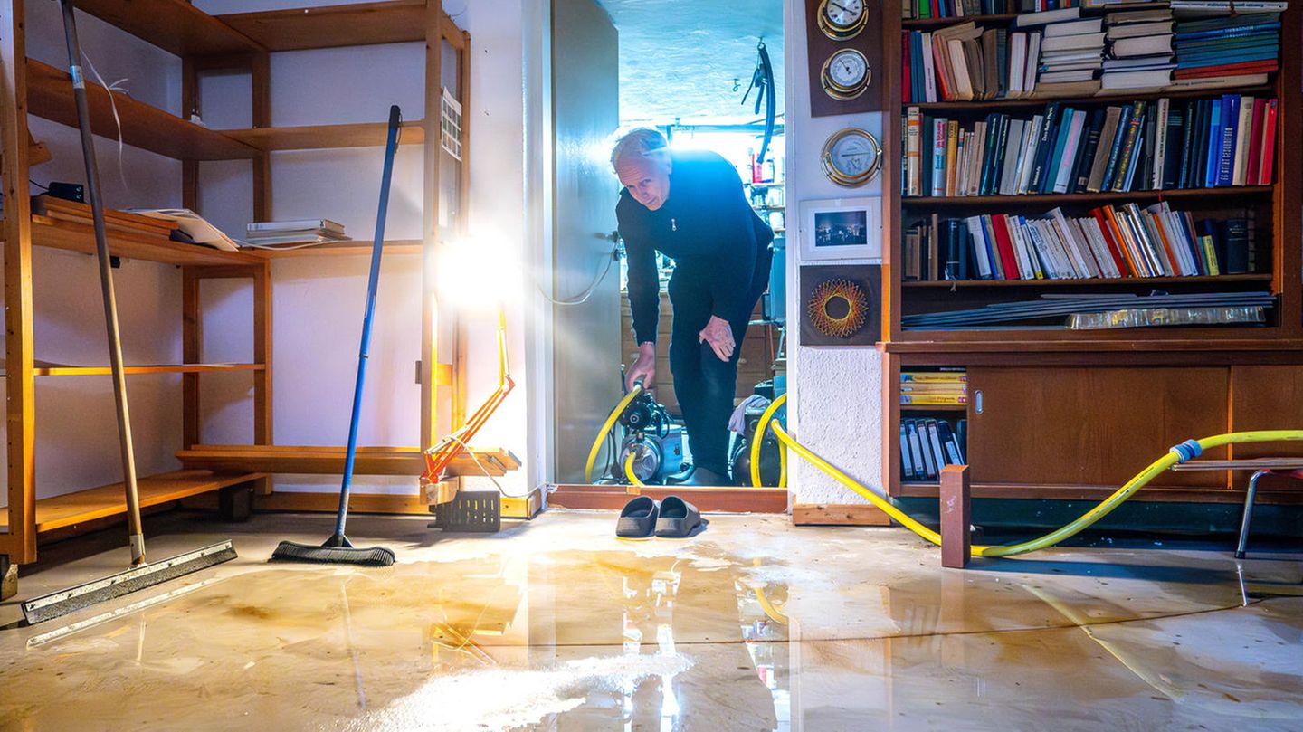 Ein Mann trägt eine Pumpe in seinen Keller im Bremer Stadtteil Borgfeld, der durch das Hochwasser überschwemmt wurde