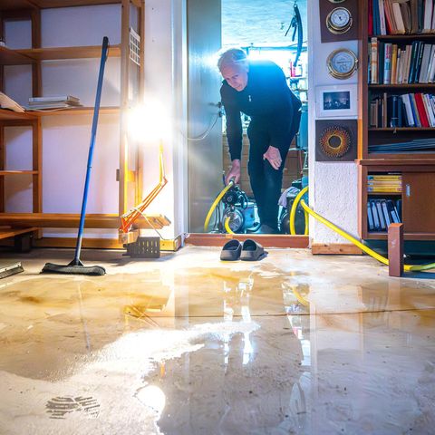 Ein Mann trägt eine Pumpe in seinen Keller im Bremer Stadtteil Borgfeld, der durch das Hochwasser überschwemmt wurde