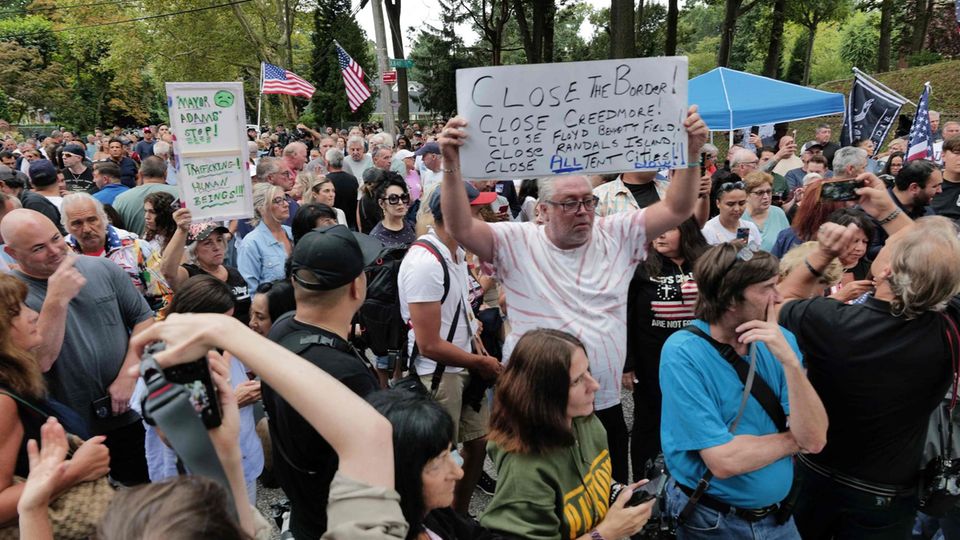 Eine Gruppe Demonstranten, teils mit Schildern, steht eng zusammen Eine Gruppe Demonstranten, teils mit Schildern, steht eng zusammen