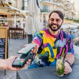 Ein junger Mann zahlt mit seiner EC-Karte in einem Restaurant auf Malta