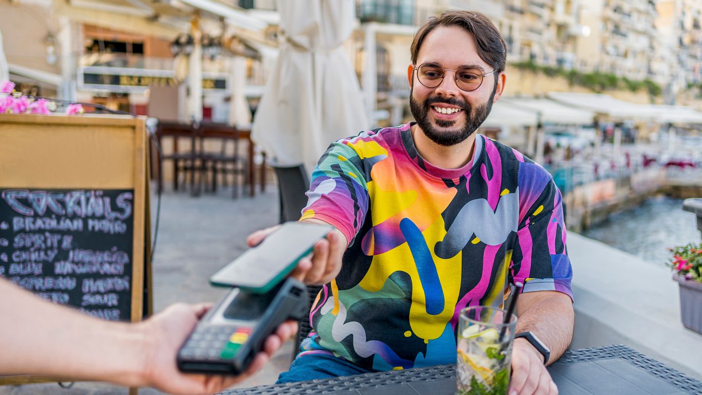 Ein junger Mann zahlt mit seiner EC-Karte in einem Restaurant auf Malta Ein junger Mann zahlt mit seiner EC-Karte in einem Restaurant auf Malta