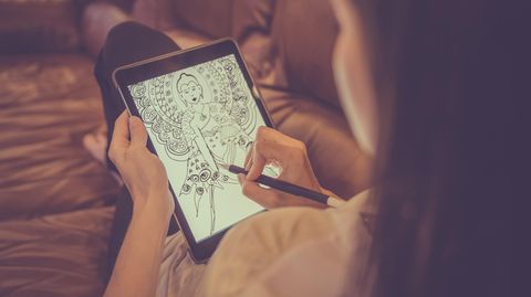Eine Frau zeichnet eine Figur auf ihrem Paper-Tablet