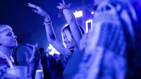 Ein londes Mädchen tanzt im Club in einer Menschenmenge