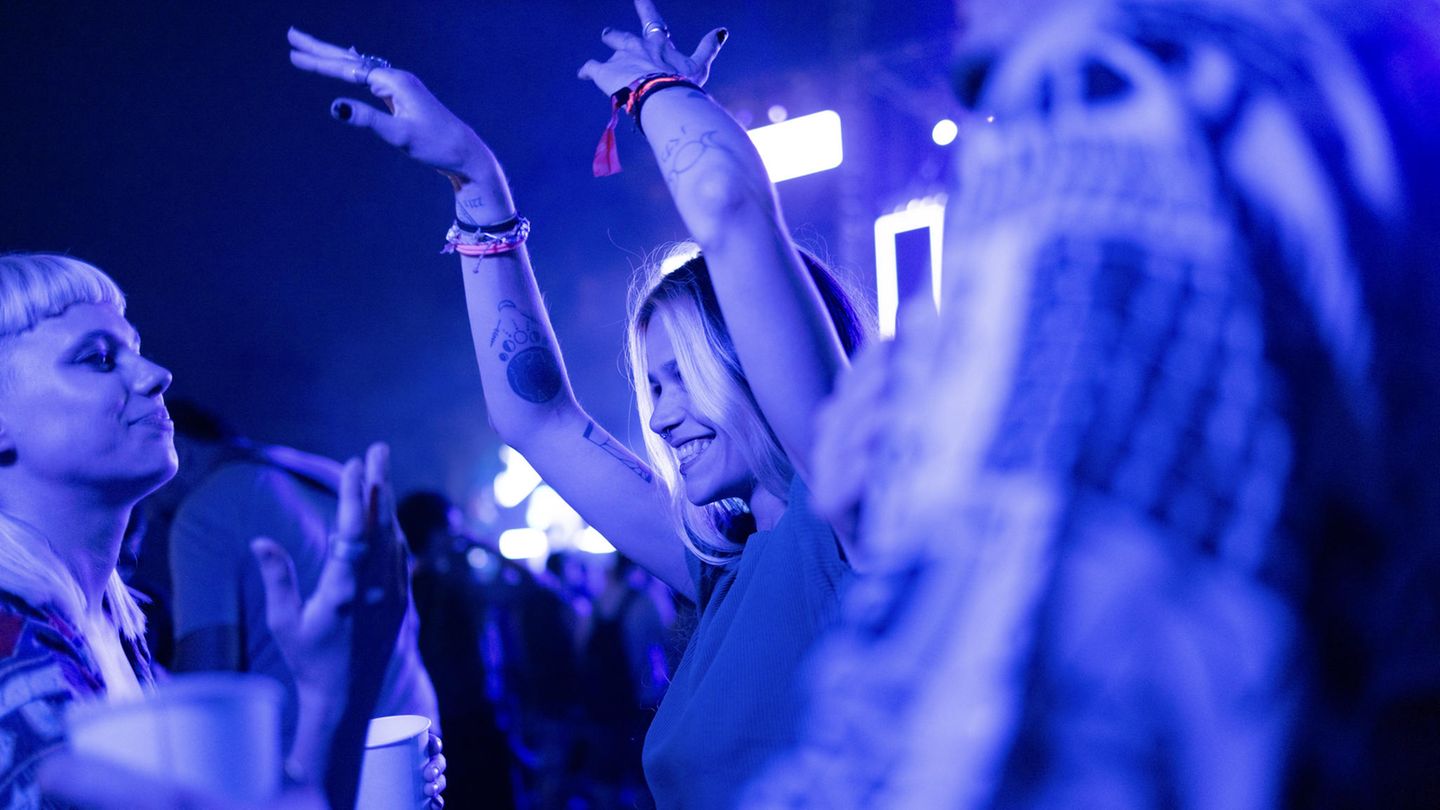 Ein londes Mädchen tanzt im Club in einer Menschenmenge