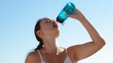 durstige Frau trinkt aus einer Wasserflasche