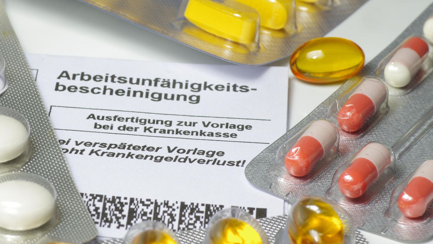 Medikamentenblister liegen auf einer Arbeitsunfähigkeitsbescheinigung Medikamentenblister liegen auf einer Arbeitsunfähigkeitsbescheinigung