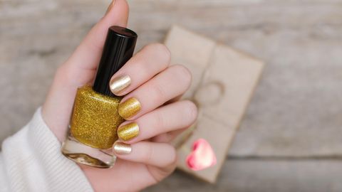Weibliche Hände mit gold Nageldesign