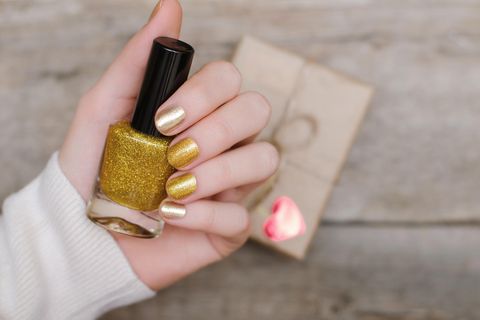 Weibliche Hände mit gold Nageldesign