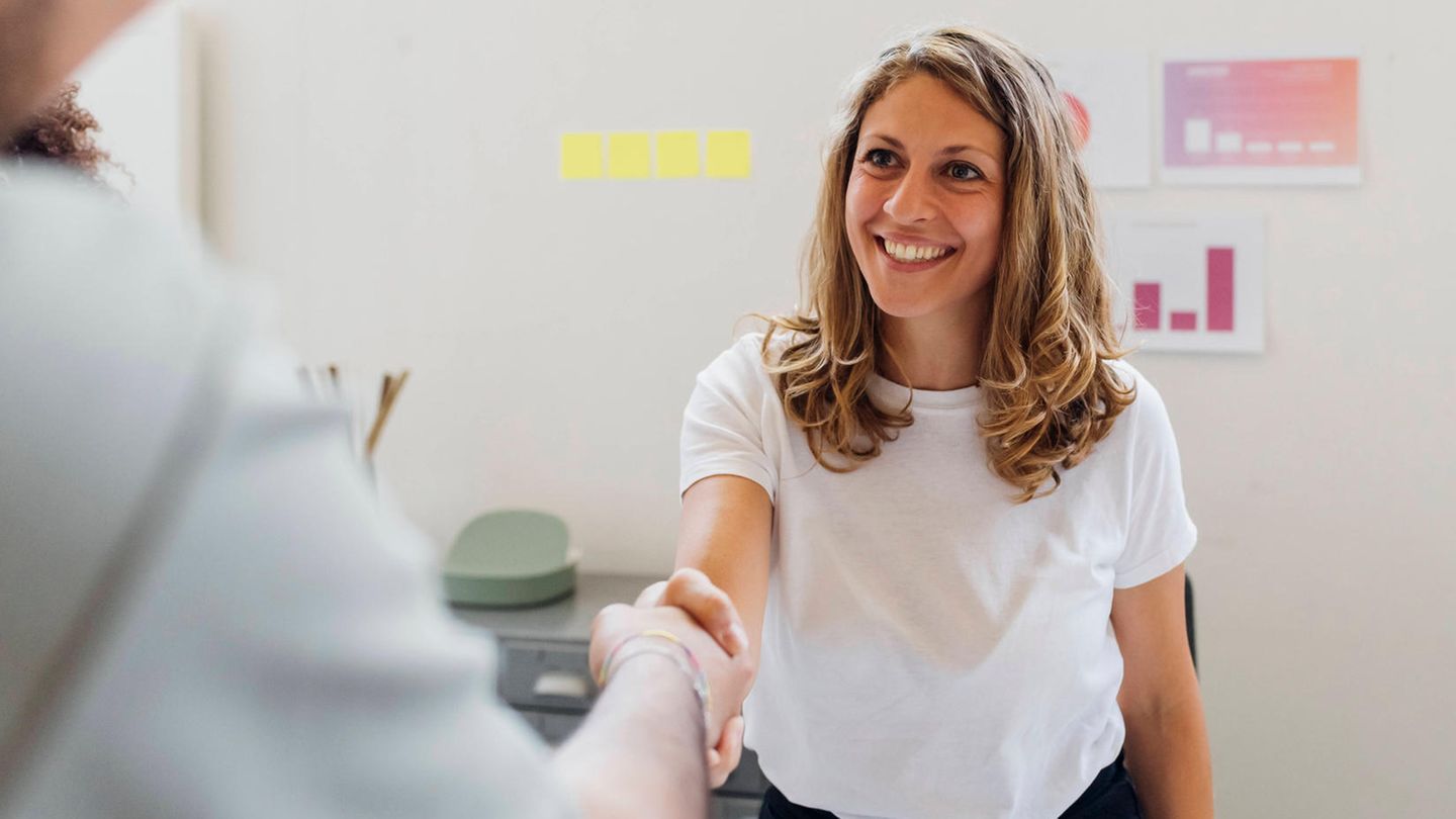 Bewerbungsgespräch: Eine Frau schüttelt einem Mann die Hand und lächelt