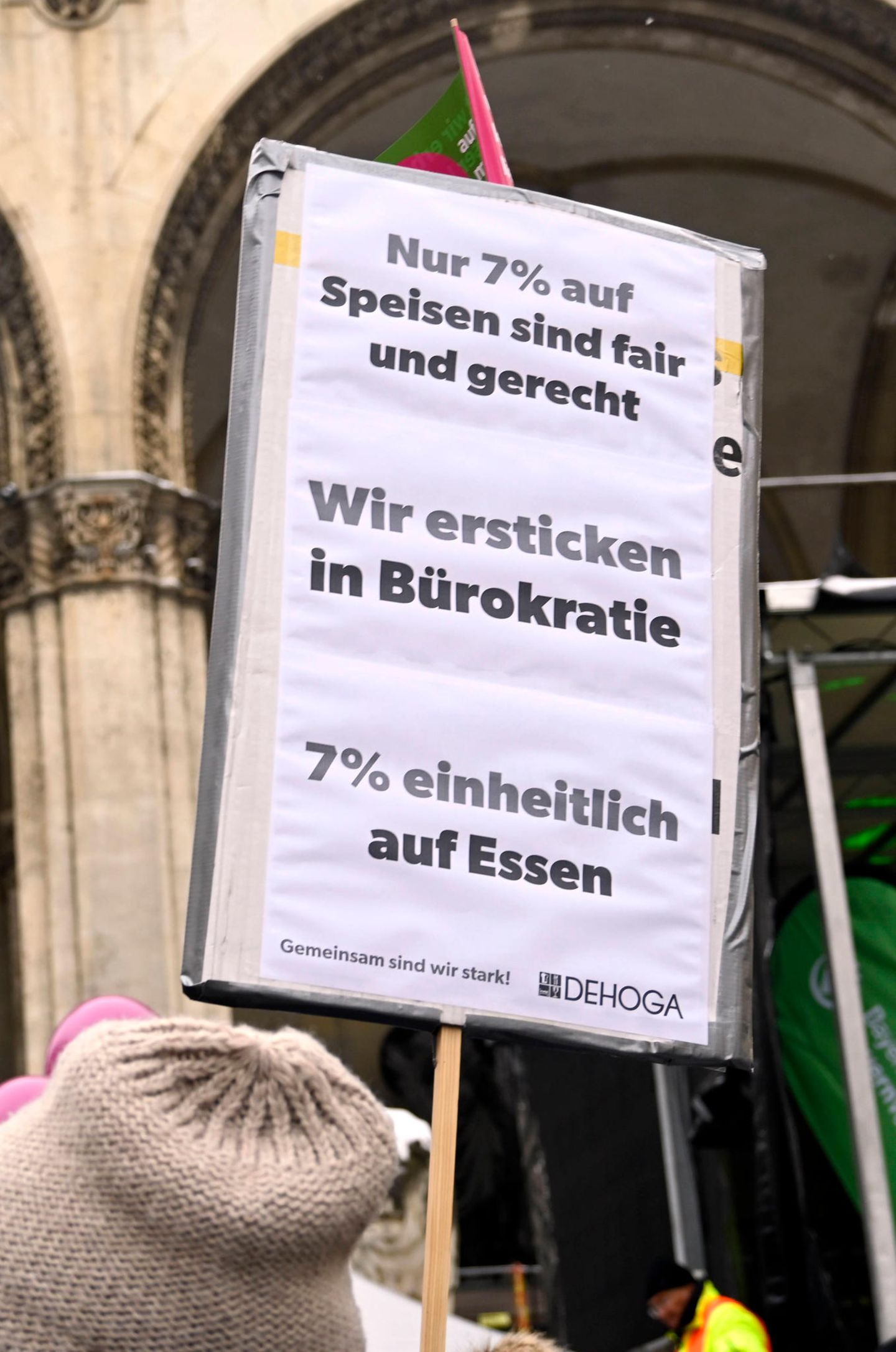 Auf einem Schild fordern Protestierende 7 statt 19 Prozent Mehrwertsteuer