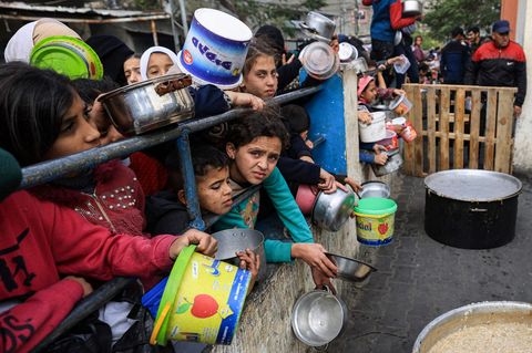 Palästinensische Kinder warten an einer Ausgabestelle in Rafah auf ein bisschen Essen.