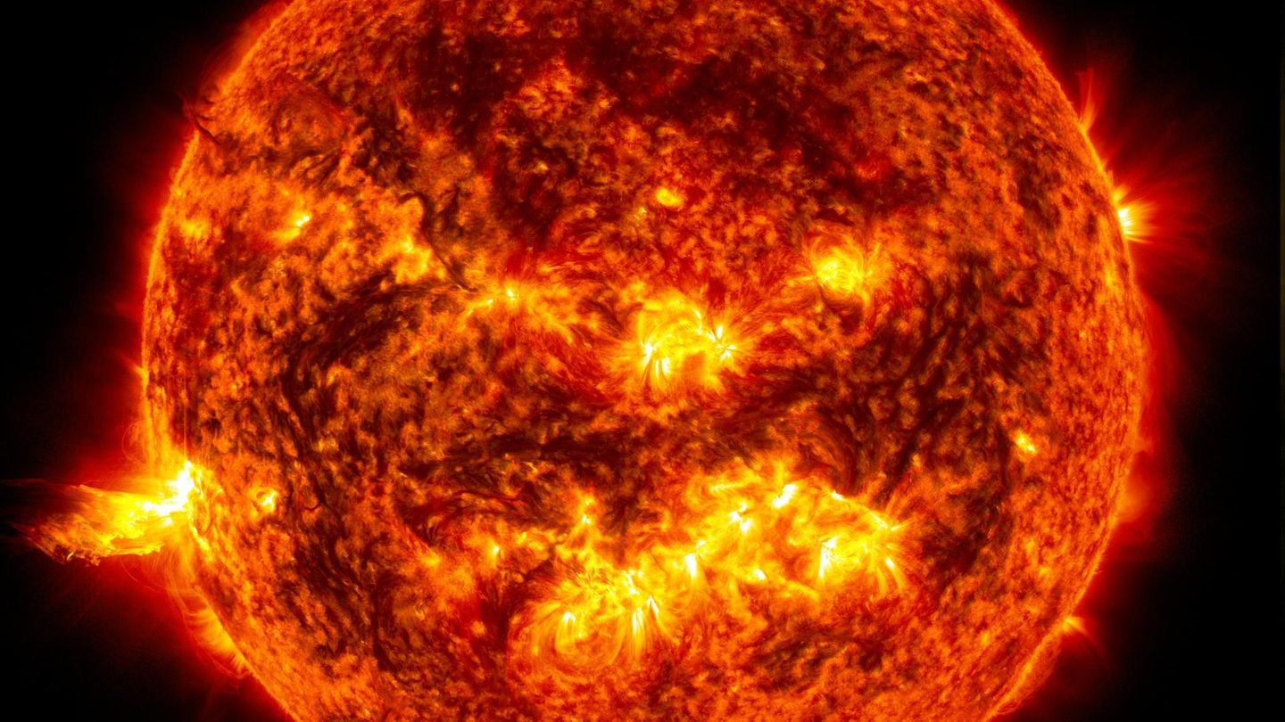 Das helle Licht einer Sonneneruption auf der linken Seite der Sonne Das helle Licht einer Sonneneruption auf der linken Seite der Sonne
