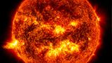 Das helle Licht einer Sonneneruption auf der linken Seite der Sonne