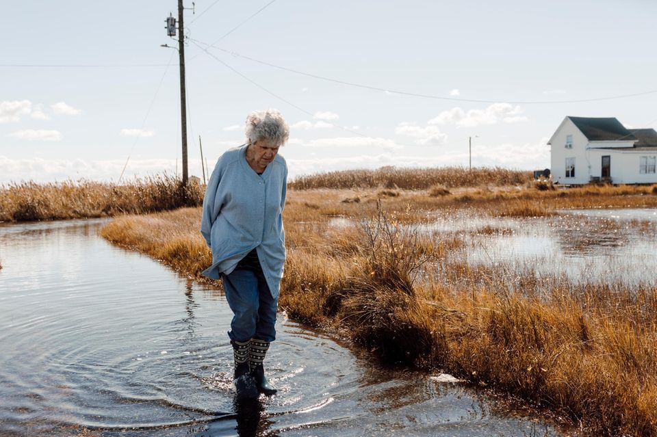 Brenda Laird walks through the standing water on the street Brenda Laird walks through the standing water on the street