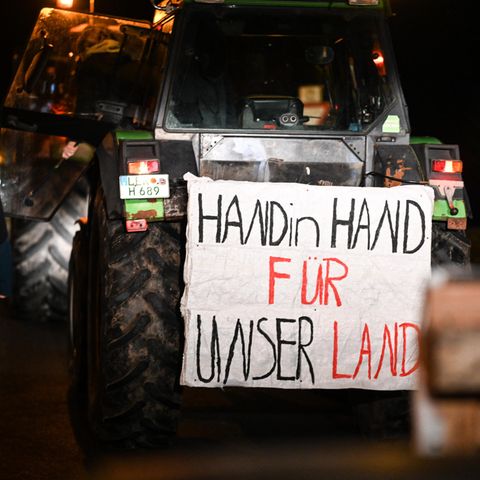 "Hand in Hand für unser Land" steht auf einem Plakat bei den Bauernprotesten