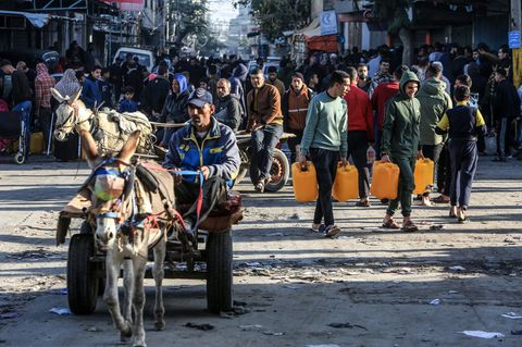 Palästinenser mit Flaschen und Kanistern laufen durch Rafah im Gazastreifen